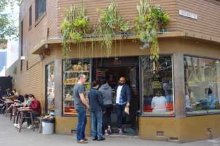 People sitting in the sun outside a coffee shop