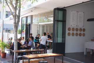 People sitting in the sun outside a coffee shop