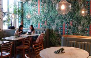Inside a coffee shop with brightly coloured wallpaper